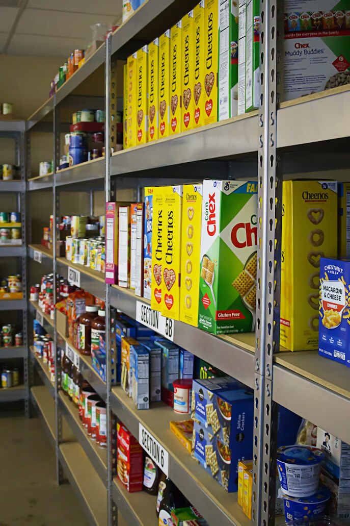 Food pantry shelves stocked with boxes and bags.