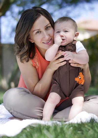 Mother holding a young child outdoors.